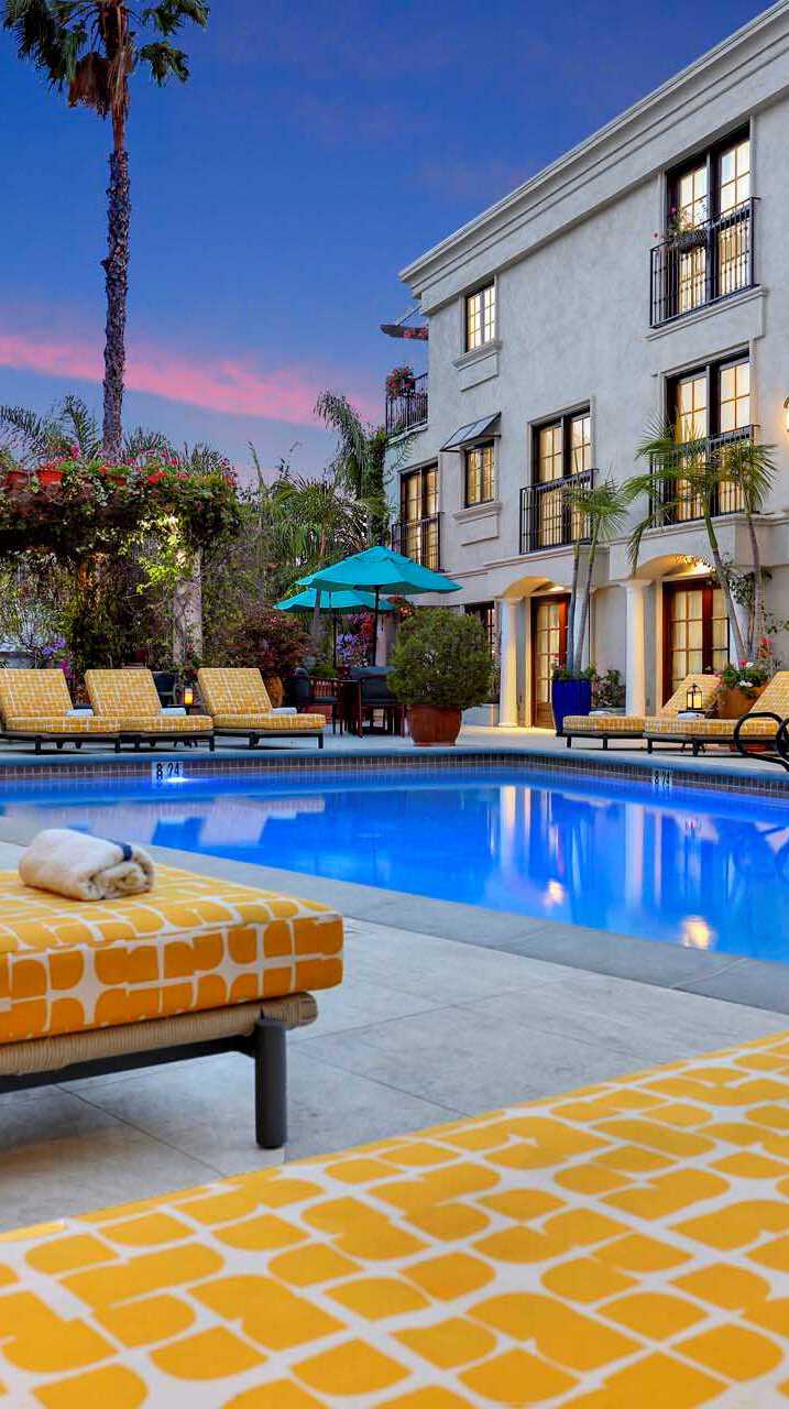 Outdoor pool surrounded by sun loungers at night