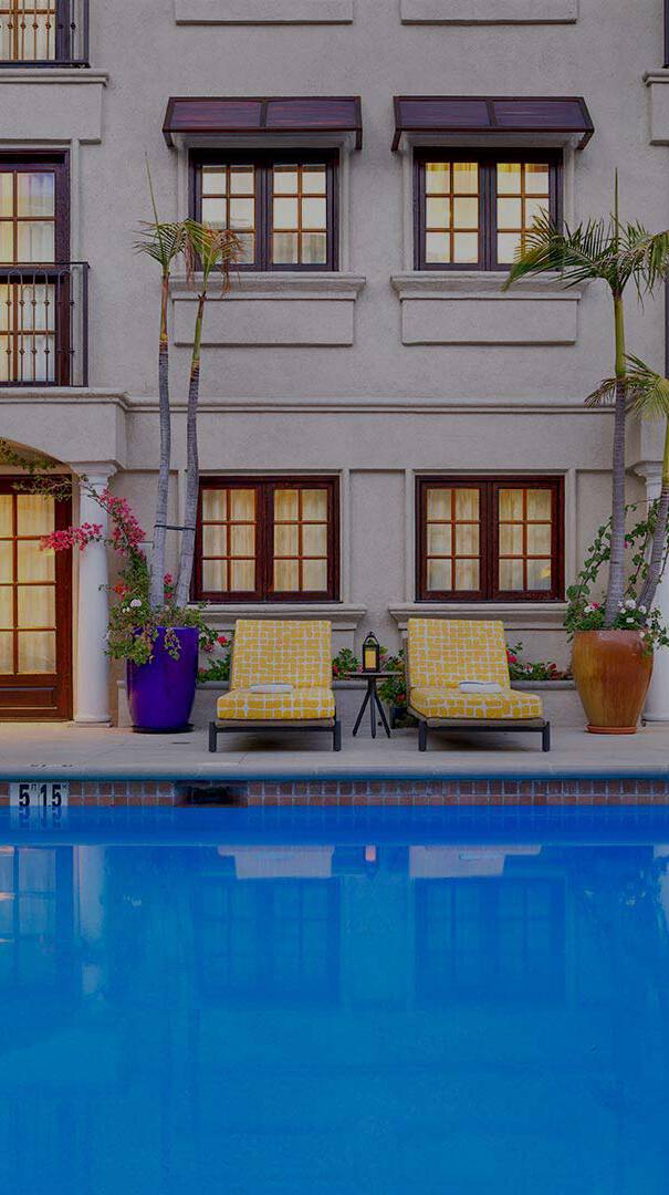 Outdoor pool surrounded by sun loungers in the evening
