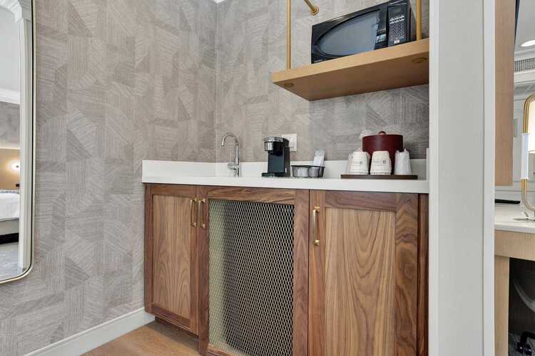 A counter with a sink, a coffee machine, and a microwave
