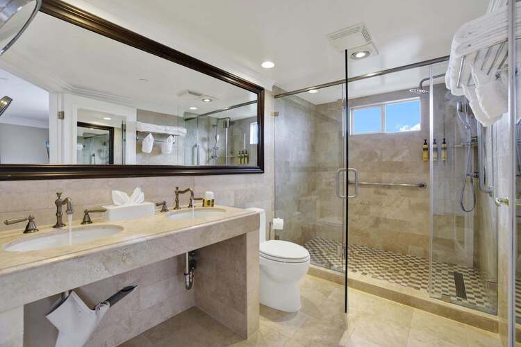 Guest bathroom with a double sink, a toilet, and a walk-in shower