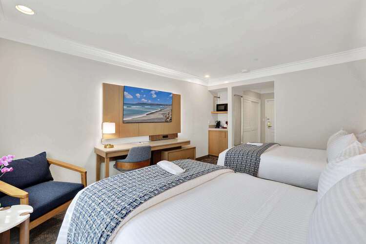 Guest room with two double beds and a work desk