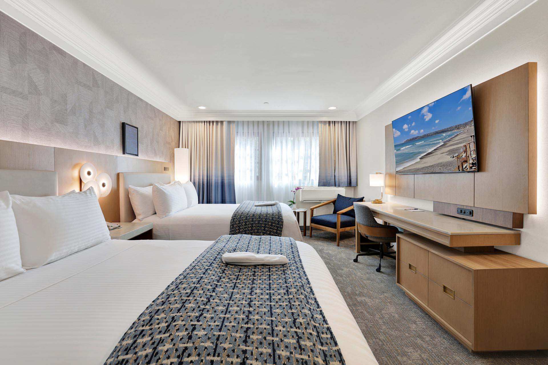 Guest room with two double beds and a desk