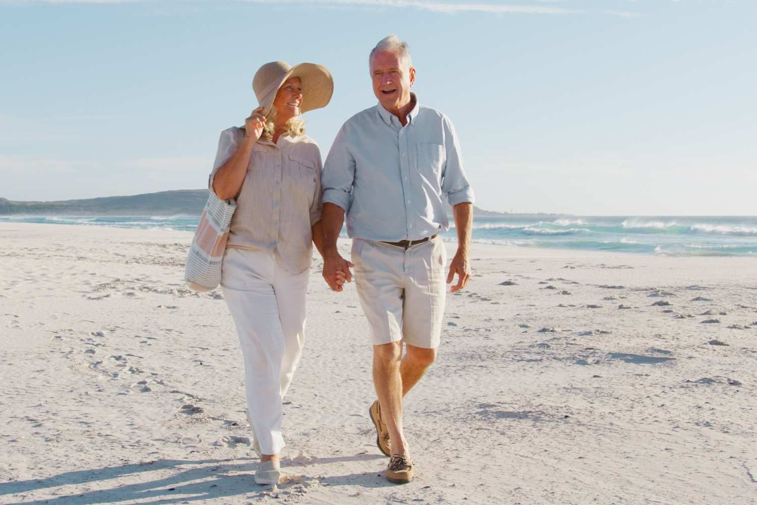A senior couple walking along the beach